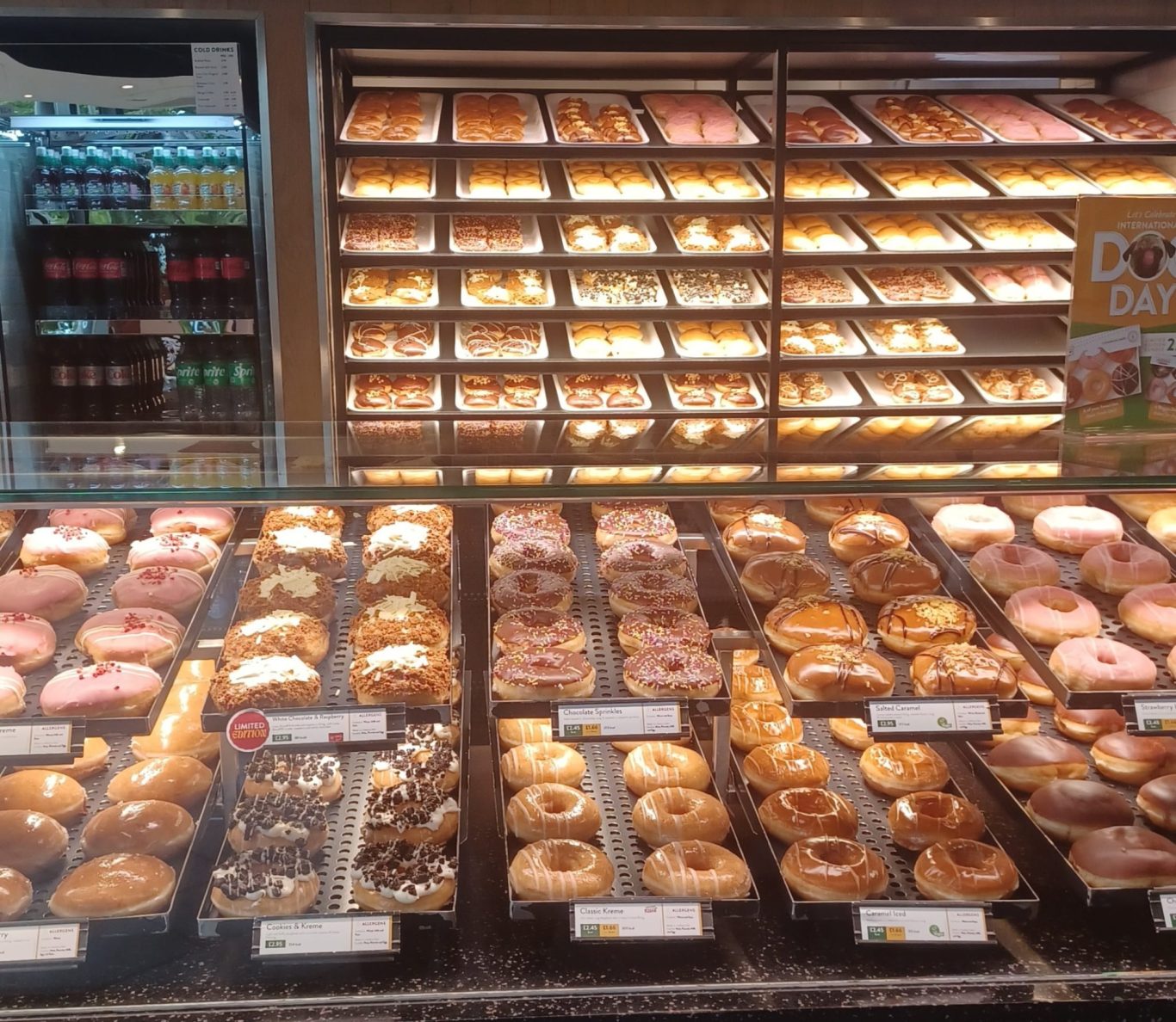 A display of various colourful donuts in a bakery setting.